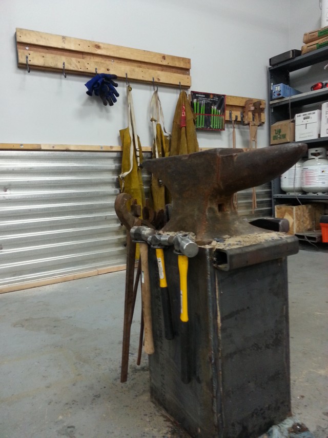 An image of an anvil with hooks in the background